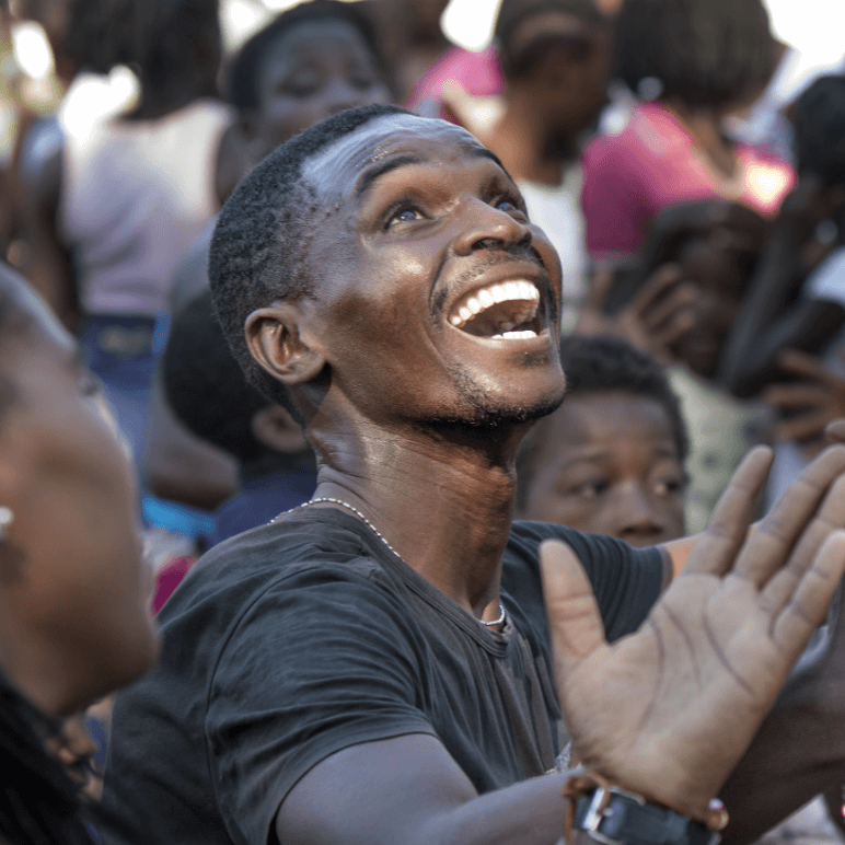 Young African man worshiping in a crowd