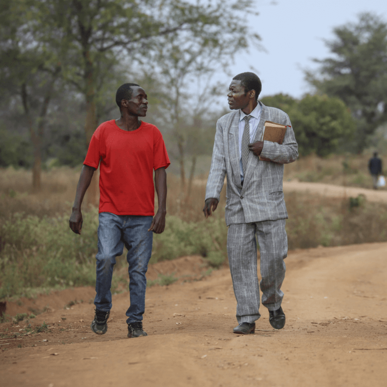 Two young African men walking and talking with each other