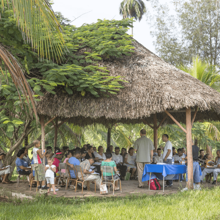 Group of Latinos under a palapa at a devotional