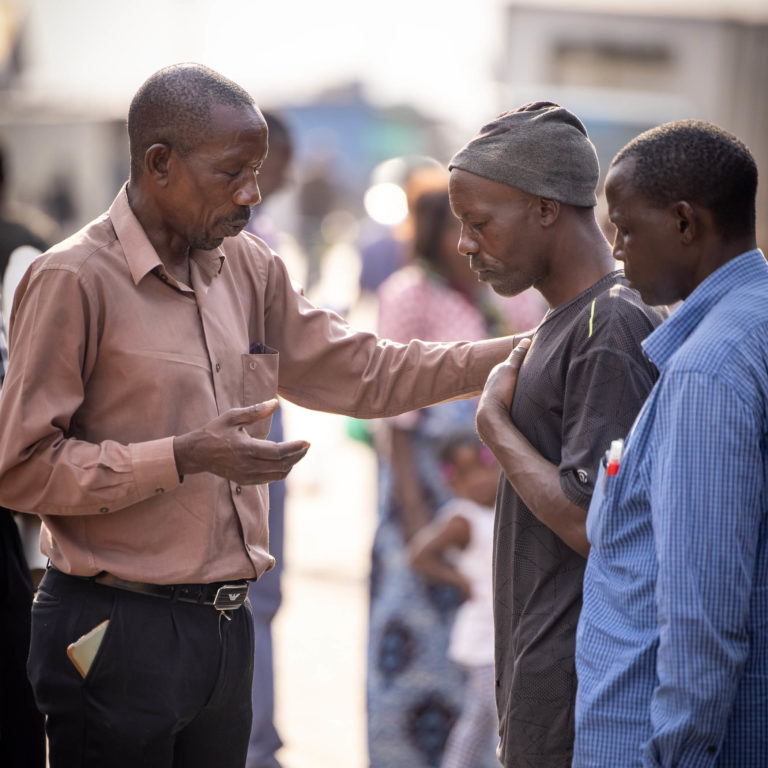 African men in the street praying